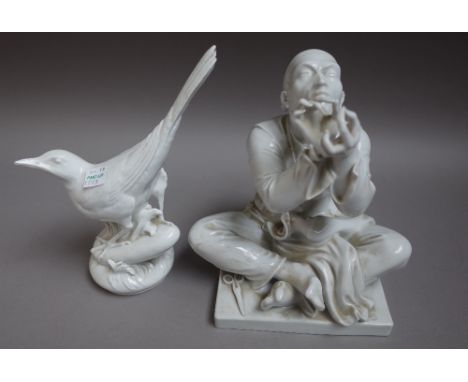 A Meissen white glazed figure of an Oriental tailor, 20th century, seated crossed legged on a square base, blue cancelled cro