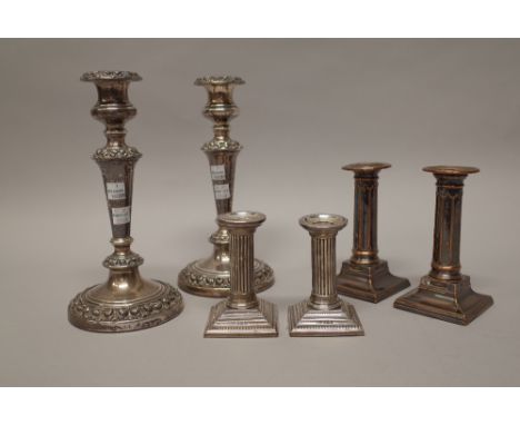 A pair of silver candlesticks, each formed as a Corinthian column, raised on a stepped square base, decorated with beaded rim