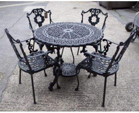 A 20th century black painted cast iron circular garden table, with pierced decoration, 92cm diameter, together with four armc