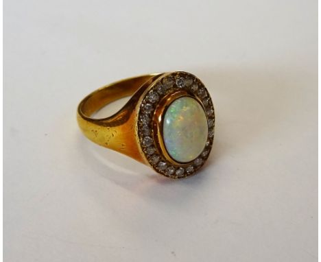 A gold, opal and diamond oval cluster ring, collet set with the oval opal in a surround of circular cut diamonds, detailed 18