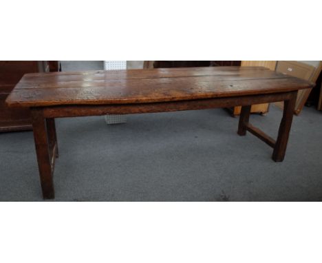 An 18th oak and elm refectory table, the plank top on block supports, united by short stretchers, 74cm wide x 227cm long.