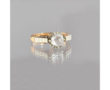 A gold and rose diamond single stone ring, claw set with the single rose diamond between scroll engraved two colour shoulders