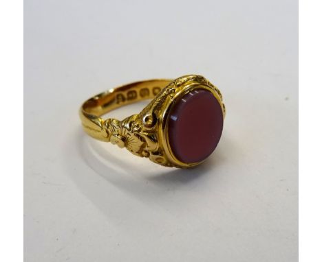 A Victorian 18ct gold and sardonyx set oval signet ring, with foliate decoration to the shoulders, Birmingham 1889, ring size