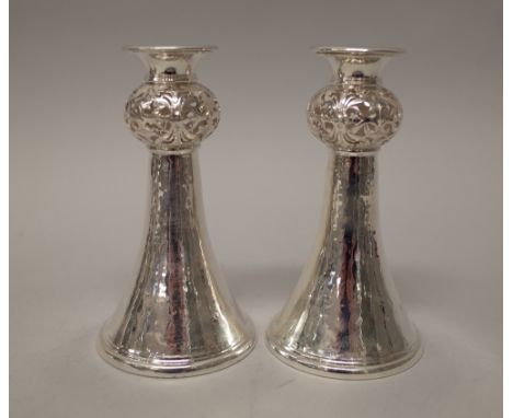 A pair of silver table candlesticks, each of flared trumpet shaped form, with a pierced bulbous stem above a flared circular 