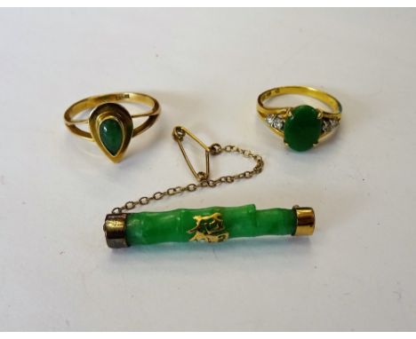 A gold ring, claw set with an oval jade between circular cut diamond set two stone shoulders, detailed 18 K 750, ring size L 