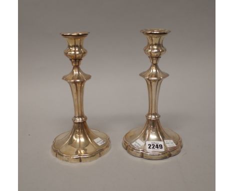 A pair of silver table candlesticks, each with a tapered stem, on a swept lobed base, Sheffield 1906, (loaded), height 21.5cm