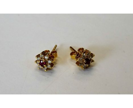 A pair of gold, ruby and diamond nine stone cluster earstuds, each claw set with the circular cut ruby to the centre, in a su