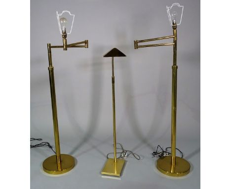 A pair of 20th century brass adjustable standard lamps, 130cm high and a 20th century brass reading light, 110cm high, (3). 