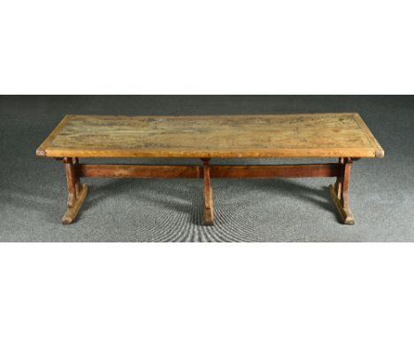 A large elm refectory table, the 19th century and later cleated twin plank top, on a trio of pierced trestle supports, united