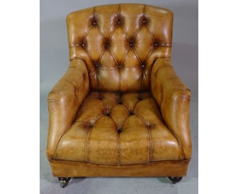 A brown leather upholstered button back easy armchair on turned supports, 80cm wide x 97cm high. 