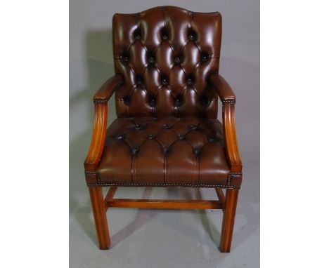 A George III style stained beech Gainsborough armchair with brown leather button back upholstery. 