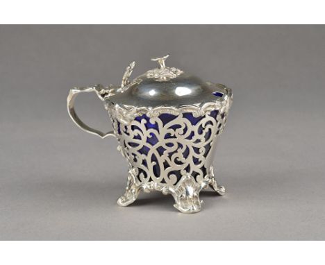 A Victorian silver mustard pot, of tapered form, with scroll pierced decoration within cast borders, the hinged lid with a fl