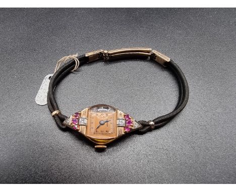 An Art Deco Emerson manual wind ladies cocktail watch, stamped 14k gold, set rubies and diamonds, on a black cord wristband w