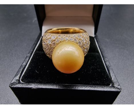 A yellow metal ring, set South Sea golden pearl and pave set diamonds, stamped AK 750, size N-O, gross weight 25.7g. 