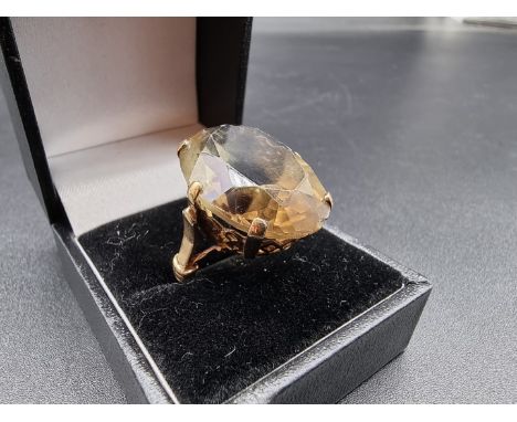 A yellow metal ring, set large oval faceted smoky quartz, stamped 9ct, size K-L. 
