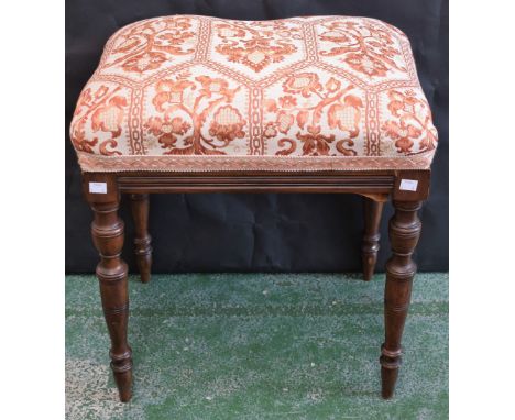 An early 20th century mahogany stool, stuffed over upholstery, turned tapered legs, 50cm wide
