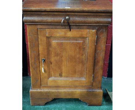 A substantial 20th century oak side cabinet, rectangular top above a long frieze drawer and a raised and fielded panel door e