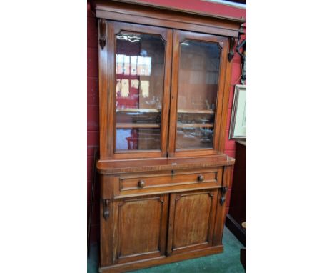 A Victorian mahogany secretaire bookcase, outswept cornice above a pair of glazed doors enclosing an arrangement of adjustabl