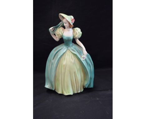 A Goebel model of a fashionable lady, she stands in green poke bonnet and dress holding a purse, ringlets in her hair, 24cm, 