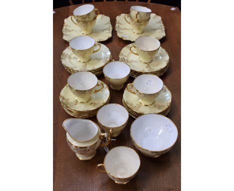 A Royal Standard part tea service, gilt on a yellow ground, including cups, saucers, side plates, two bread and butter plates