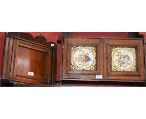 An early 20th century oak wall hanging cupboard, the shaped superstructure with a single shelf above a pair of cupboard doors