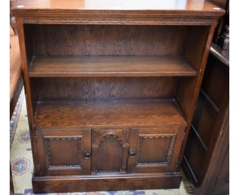 A 20th century oak bookcase, rectangular top above an adjustable shelf and a pair of panel doors, skirted base, 102.5cm high