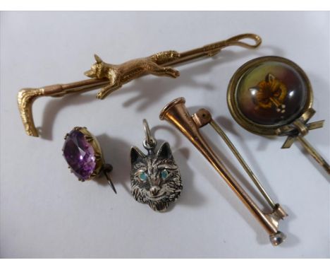 9CT GOLD FOX AND CROP STOCK PIN, A HORN PIN, AMETHYST SET DITTO, A CRYSTAL FOX HEAD PIN AND A FOX HEAD PENDANT