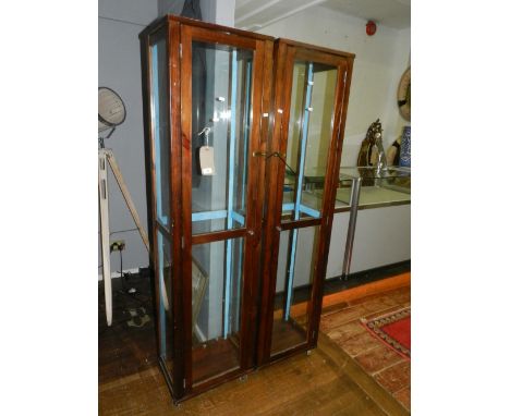 A pair of mahogany framed glass display cabinets, fitted with glass shelves and cupboard door to front, raised on bracket fee