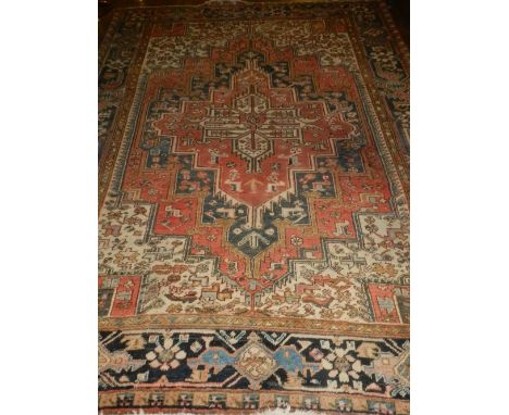 A red ground Heriz carpet, having stepped medallions to centre, within many borders, fringed, L.300cm H.239cm