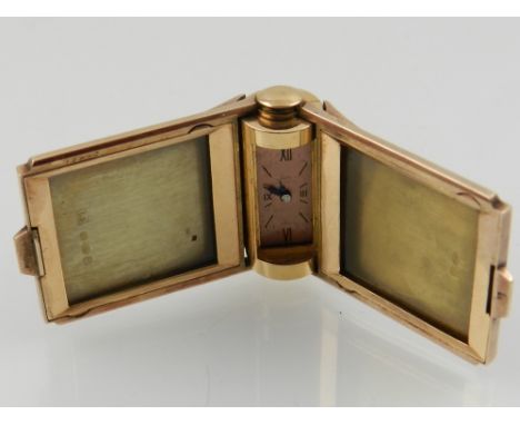 An art deco silver gilt and black enamel double photograph clip with built in time piece. dated 1939. 