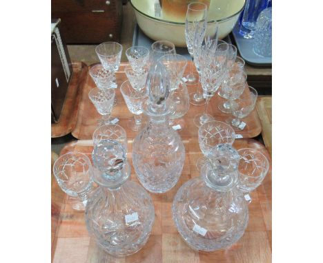 Two trays of assorted glassware to include; three cut or moulded glass decanters in various shapes, all with stoppers and sta