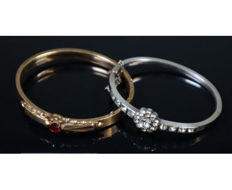 White metal bangle with clusters of white stones and a yellow metal bangle set with a red stone.(B.P. 21% + VAT) 