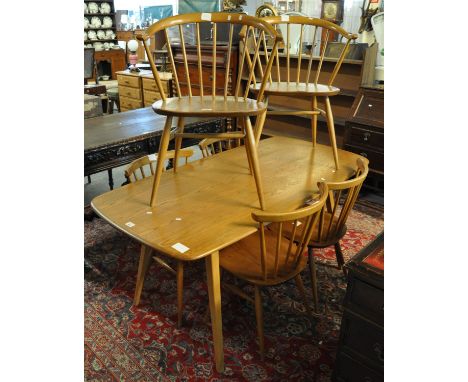 Ercol light elm kitchen table, together with a set of six ercol elm spindle chairs. Blue sticker to the back. (7) (B.P. 21% +