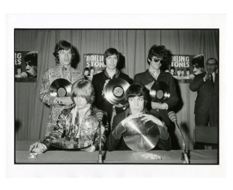 A collection of four photograph of The Rolling Stones taken by Günter Zint. One photograph is of the group being presented wi