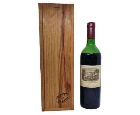 A bottle of rare Rothschild Chateau Lafite 1er Grand Cru Classe Paulliac 1983 vintage wine housed in a wooden box bearing the