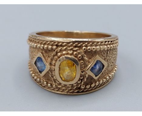 A 9ct gold dress ring set with a central Citrine flanked by Sapphire, 8gms, ring size O 