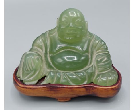 A Chinese carved jade Buddha upon hardwood stand, 5.5cms tall 