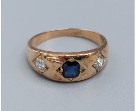 A yellow metal Diamond and Sapphire ring set with a central sapphire flanked by diamonds, 5.6gms, ring size Q 