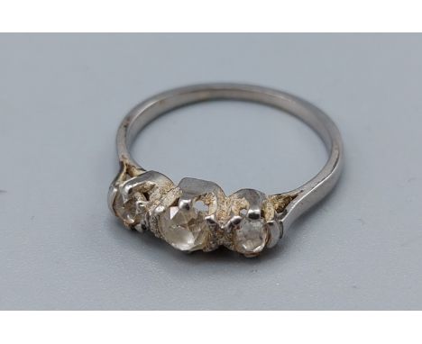 A white metal three stone diamond ring, claw set, ring size M, 3.2gms 