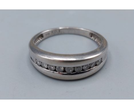 A 14ct white gold channel set Diamond ring, set with nine Diamonds, 3.8gms, ring size Q 