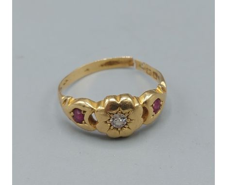 An 18ct gold ring set with central diamond flanked by rubies, ring size O, 2.9gms 