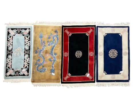 Collection of four Chinese washed woollen rugs - blue ground (153cm x 92cm); red and black ground (156cm x 94cm); light blue 