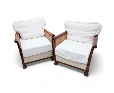Pair of early 20th century mahogany framed bergère armchairs, upholstered back and seat flanked by rolled double-caned arms w