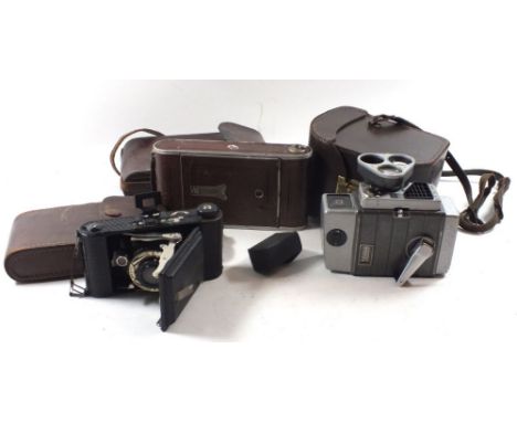 A Zeiss Icon folding camera Contessa Nettel, an Ensign Selfix camera and a Bell and Howell cine camera 