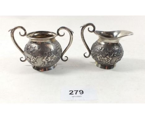 A Chinese silver cream jug and sugar bowl decorated prunus, with hallmarks to base, 5.5cm tall, 114g 