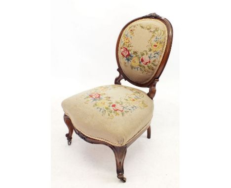 A Victorian walnut framed chair with tapestry floral covers to oval carved back and seat all on scroll supports 