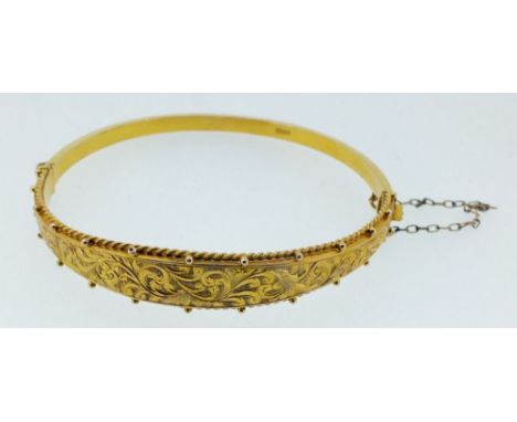 A Victorian 9 carat gold engraved and hinged bangle, boxed, 6g 