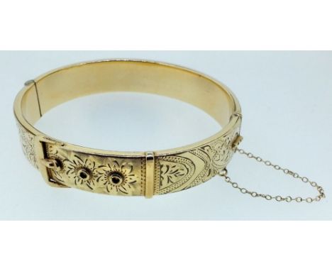 A 9 carat gold on metal core buckle form bangle with engraved decoration, total weight 24g 
