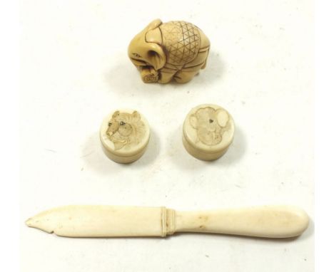 Two Meiji period ivory Japanese pill boxes with engraved lion and elephant head, an antique ivory letter opener and an elepha