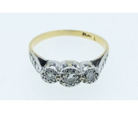 An early 20th century 18 carat gold and platinum set three stone diamond ring, size K to L, 2g 